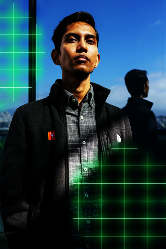 A young man stands confidently against a reflective glass wall, wearing a black jacket and gray checkered shirt, with neon green grid patterns overlaying parts of the image.